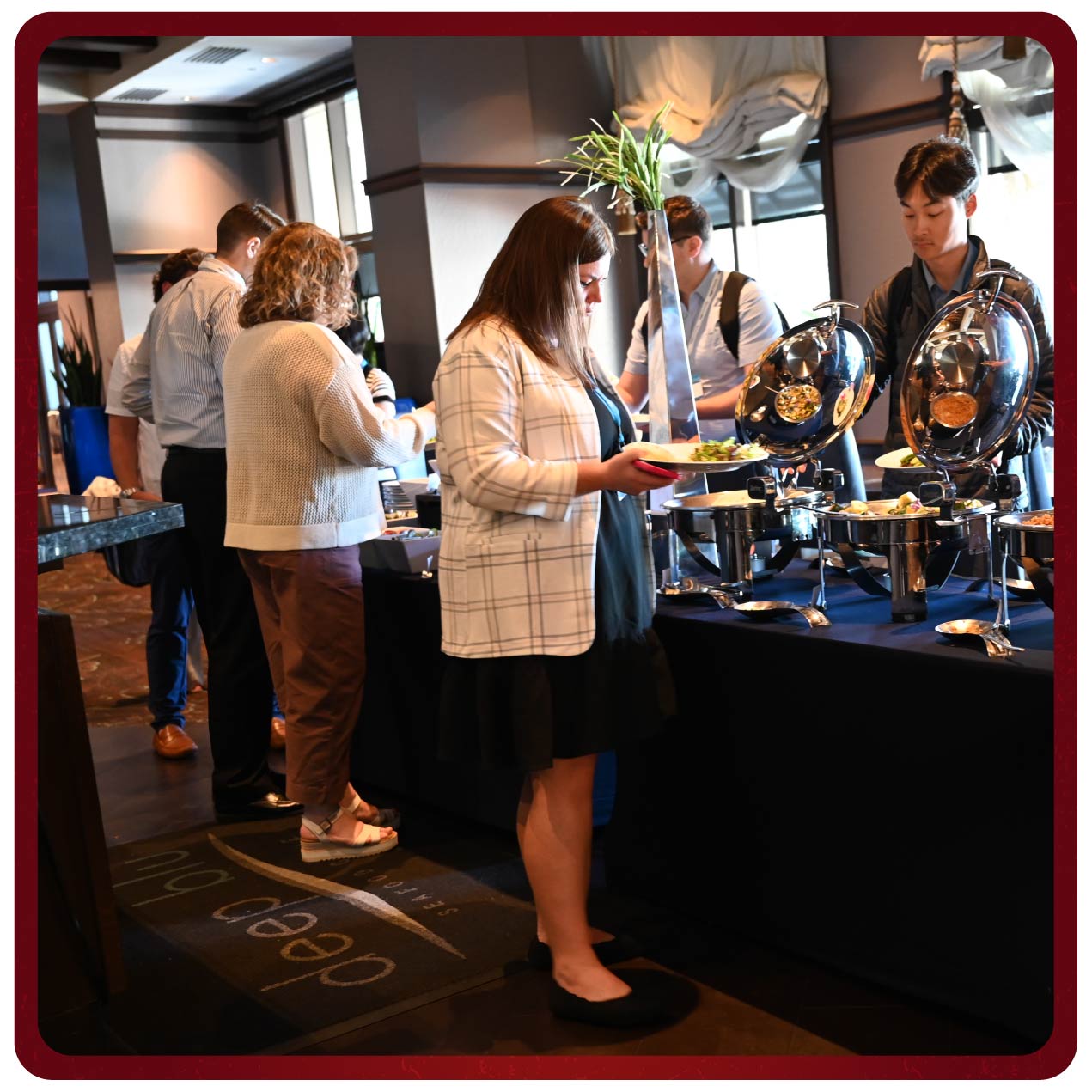 Attendees fill their plates at a fancy buffet table